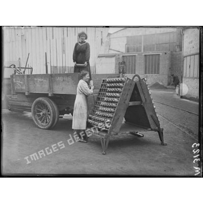 Paris, usine Citroën du quai de Javel. Femme de l'usine transportant des obus. [légende d'origine]