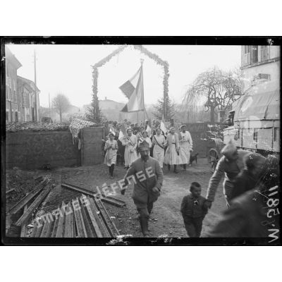 Maizières-les-Vic, défilé de jeunes lorraines passant sous un arc de triomphe le jour de la réception du général Philipot. [légende d'origine]
