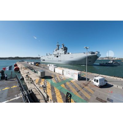 Le bâtiment de projection et de commandement (BPC) Le Tonnerre mouille aux côtés du remorqueur-pousseur Estérel à quai de la base navale de Toulon.