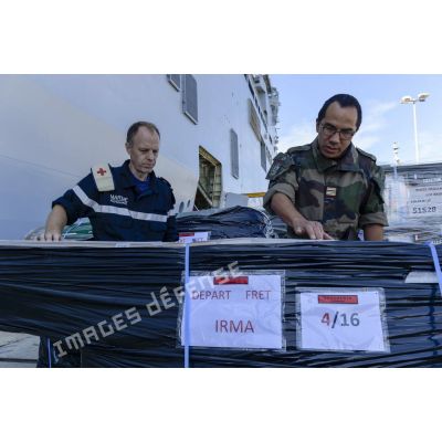 Un chirurgien-dentiste en chef secondé d'un major prend en compte le matériel médical à charger à bord du bâtiment de projection et de commandement (BPC) Le Tonnerre  à Toulon.
