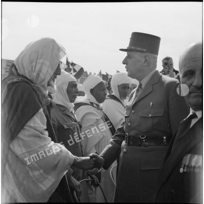 Le général de Gaulle salue des anciens combattants.