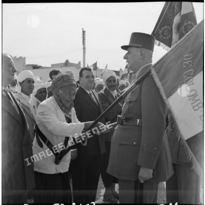 Le général de Gaulle salue des anciens combattants.