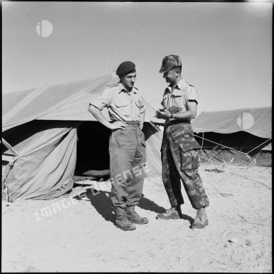 Le capitaine Griffiths de la 6e brigade de parachutistes anglais s'entretient avec le capitaine André Guillaume du 2e RPC au camp X (Chypre).