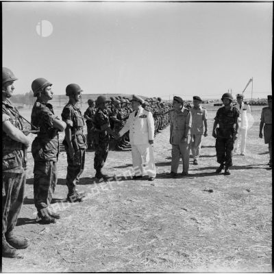 Accompagné du général Gilles et du colonel Gracieux, le vice-amiral d'escadre Barjot passe des parachutistes en revue, au camp X (Chypre).