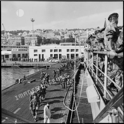 Les légionnaires du 1e REP embarquent à bord du cuirassé Jean Bart dans le port d'Alger.