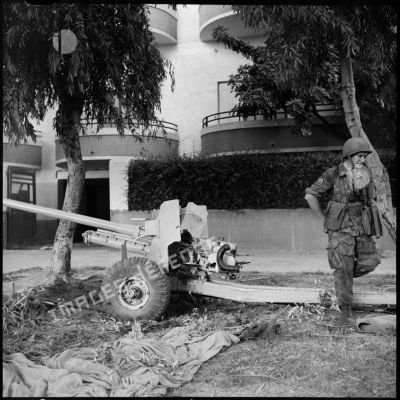Un canon antichar britannique utilisé par l'armée égyptienne et un sergent-chef du 1er REP (régiment étranger de parachutistes) dans une rue de Port-Fouad.