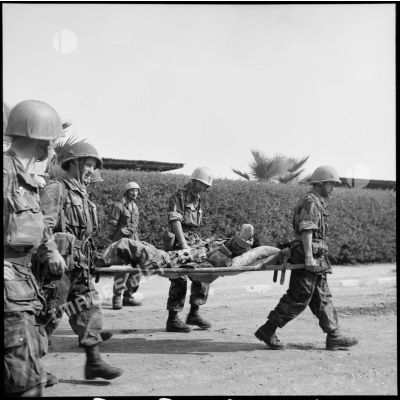 Un parachutiste blessé est évacué par les légionnaires du 1er REP à Port-Fouad.