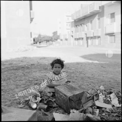 Une petite fille fouille dans une poubelle, après le cessez-le-feu à Port-Saïd.