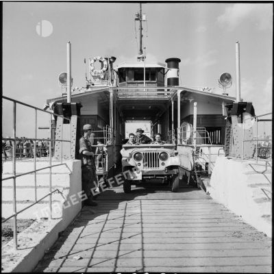 Sous la surveillance de parachutistes français, une jeep quitte le ferry assurant la traversée du canal de Suez entre Port-Saïd et Port-Fouad.