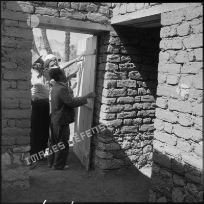Pose d'une porte à un nouveau logement du village de Khangat-Sidi-Nadji.