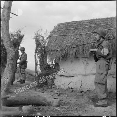 Deux soldats en faction devant une maison dans un douar.