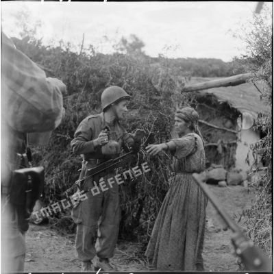 Un soldat discute avec une femme dans un douar.