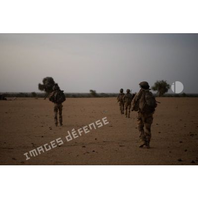 Un groupe de soldats entame une progression en direction d'un village au lever du soleil dans le Gourma malien.