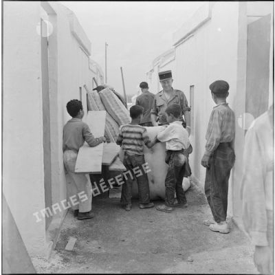 Des enfants s'installent dans leur logement de la cité "La Montagne" sous le regard d'un soldat.