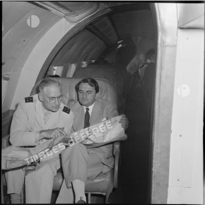 Max Lejeune, ministre du Sahara, et le général Quenard, commandant les troupes et services des territoires du sud, consultant la carte dans l'avion ministériel qui les ramène à Tamanrasset.