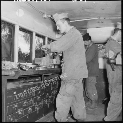 Des soldats de la 407ème compagnie de réparation divisionnaire (CRD) travaillent sur des machines dans un atelier.