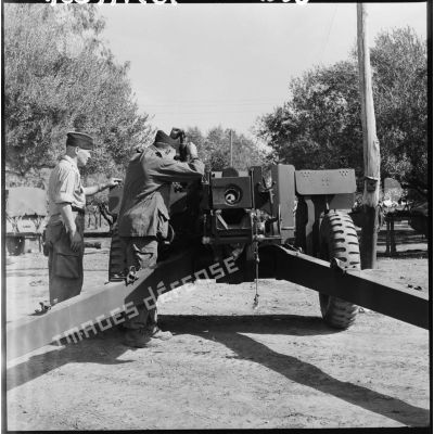 Des soldats de la 407ème compagnie de réparation divisionnaire (CRD) vérifient une pièce d'artillerie 105 HM2 A1.<br>