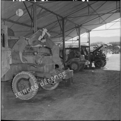 Des soldats de la 407ème compagnie de réparation divisionnaire (CRD) travaillent sur des camions dans l'atelier.