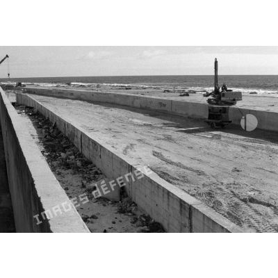 Construction du 2e mur de protection de la zone vie côté océan par la Compagnie des Travaux (CT). [Description en cours]