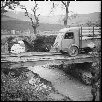 Passage d'un camion Renault R 2086 sur le pont militaire construit par le génie de la 27e division d'infanterie algérienne (DIA).