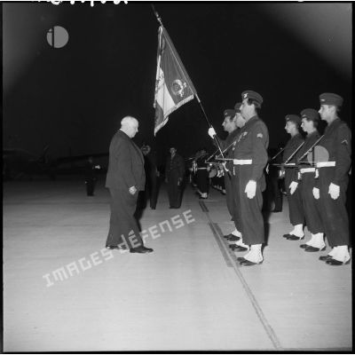 Louis Christiaens s'incline devant le drapeau de l'armée de l'air.