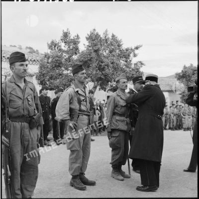 Le colonel Héritier, commandant le secteur de El Kseur, remet la croix de la Valeur Militaire à un harki.
