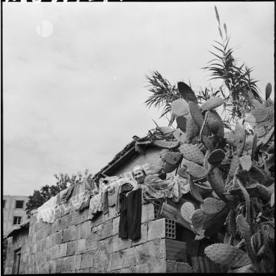 Femme arabe devant son habitation.