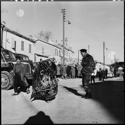 L'adjudant Bardon du quartier général (QG) de la 10ème division des parachutistes (DP) marchandant un tapis dans le village de Fort National.