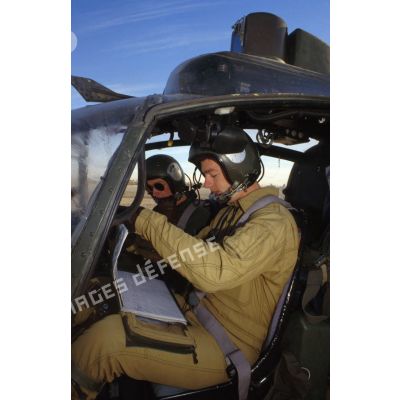 Deux pilotes de l'ALAT (aviation légère de l'armée de terre) se préparent avant leur départ en mission à bord d'un hélicoptère de combat Gazelle.