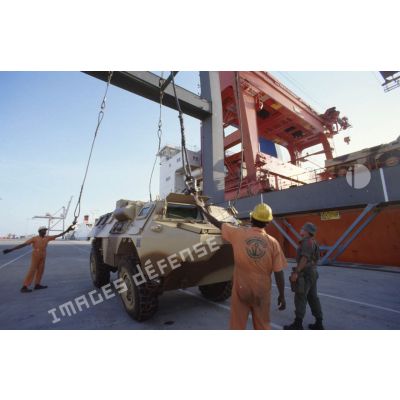Déchargement d'un VAB à l'aide d'une grue par des ouvriers dockers locaux sur le quai du port de Yanbu.