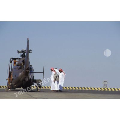 Un groupe de Saoudiens examine un hélicoptère de combat Gazelle de l'ALAT (aviation légère de l'armée de terre) aux pales démontées déchargé sur un quai du port de Yanbu.