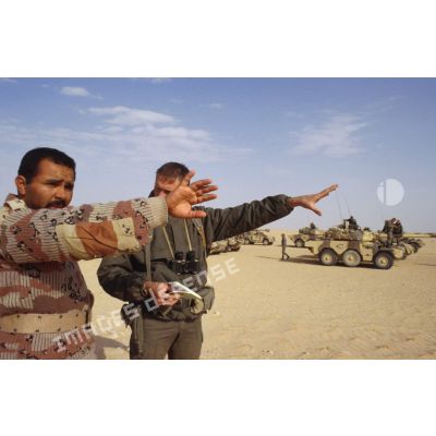 Un soldat demande sa route dans le désert à un militaire saoudien, à l'aide d'un dictionnaire, pour la colonne de blindés de reconnaissance ERC-90 Sagaie du 1er RHP (régiment de hussards parachutistes).
