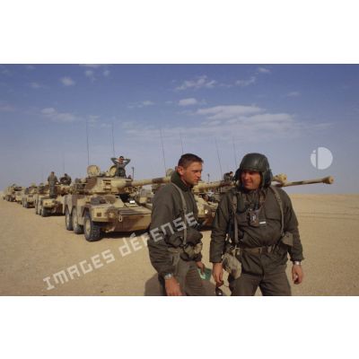 Deux soldats se concertent sur la route à prendre dans le désert d'après les renseignements fournis par des militaires saoudiens à l'aide d'un dictionnaire, pour la colonne de blindés de reconnaissance ERC-90 Sagaie du 1er RHP (régiment de hussards parachutistes).
