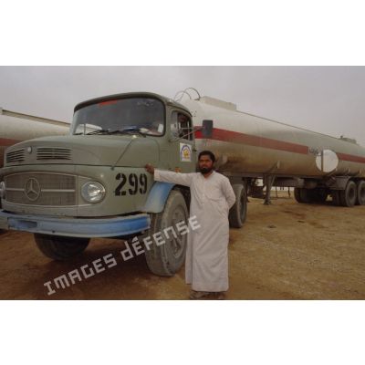 Chauffeur local devant son camion-citerne Mercedes qui ravitaille le dépôt d'essence à la base arrière du SEA (Service des essences des armées).