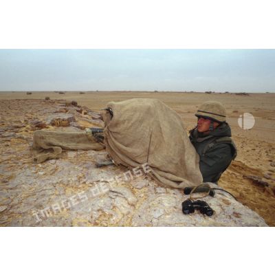 Portrait d'un soldat sur un poste de tir de lance-missiles Milan camouflé en ZDO (zone de déploiement opérationnel) Olive, retranché derrière un remblai de pierres.