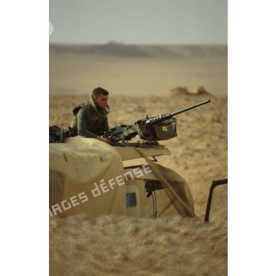 En ZDO (zone de déploiement opérationnel) Olive. Un soldat est en observation sur le toit d'un camion, derrière une mitrailleuse 12,7 mm.