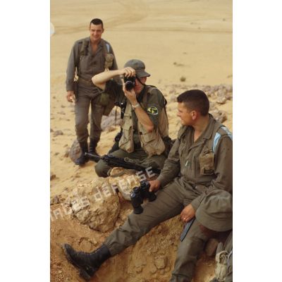 Portrait de soldats dans un poste d'observation en ZDO (zone de déploiement opérationnel) Olive, armés de fusils d'assaut FAMAS. Un photographe de l'ECPA (Etablissement cinématographique et photographique des Armées) en action.