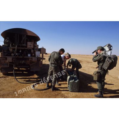 En ZDO (zone de déploiement opérationnel) Olive, le chef caméraman de l'ECPA (Etablissement cinématographique et photographique des Armées) filme un ravitaillement en essence en plein désert.