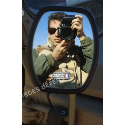 En ZDO (zone de déploiement opérationnel) Olive, autoportrait du photographe de l'ECPA (Etablissement cinématographique et photographique des Armées) dans le rétroviseur du véhicule Peugeot P4. Il porte un patch "presse aux armées".