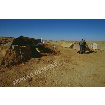 En ZDO (zone de déploiement opérationnel) Olive, le caméraman et le preneur de son de l'ECPA (Etablissement cinématographique et photographique des Armées) devant les tentes canadiennes, près de leur tente-abri.