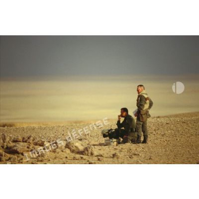 En ZDO (zone de déploiement opérationnel) Olive, le caméraman et le preneur de son de l'ECPA (Etablissement cinématographique et photographique des Armées) sont en attente dans le désert.