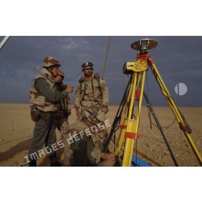 En ZDO (zone de déploiement opérationnel) Olive, des soldats français géographes dont un capitaine présentent des instruments de mesure  topographiques à des militaires américains de la 101e Airborne.