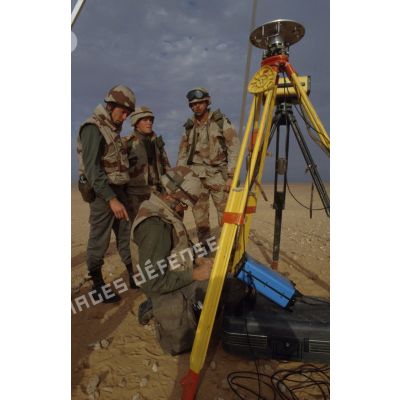 En ZDO (zone de déploiement opérationnel) Olive, des soldats français géographes dont un capitaine présentent des instruments de mesure  topographiques à des militaires américains de la 101e Airborne.