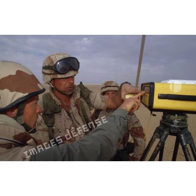 En ZDO (zone de déploiement opérationnel) Olive, un capitaine français géographe présente des instruments de mesure  topographiques à des militaires américains de la 101e Airborne.