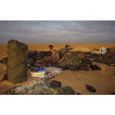 Un soldat américain dans son trou de survie, entouré de tout son équipement, aux alentours du CRK (camp du roi Khaled).
