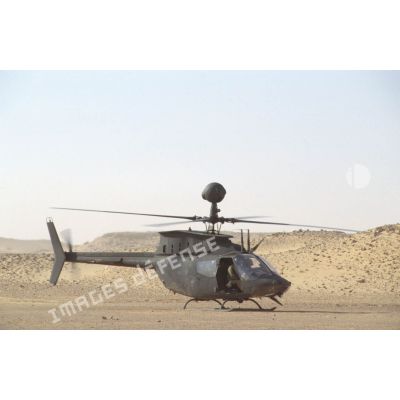 Aux alentours du CRK (camp du roi Khaled), un hélicoptère de reconnaissance et d'observation Bell-OH58 Kiowa muni d'un système de visée installé au-dessus du rotor au sol.