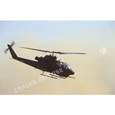 Aux alentours du CRK (camp du roi Khaled), un hélicoptère de lutte antichar Bell 209 Huey-Cobra en vol.