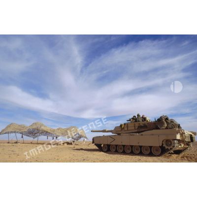 En ZDO (zone de déploiement opérationnel) Olive, char de combat Abrams-M1 américain dans le désert se dirige vers un filet de camouflage tendu.