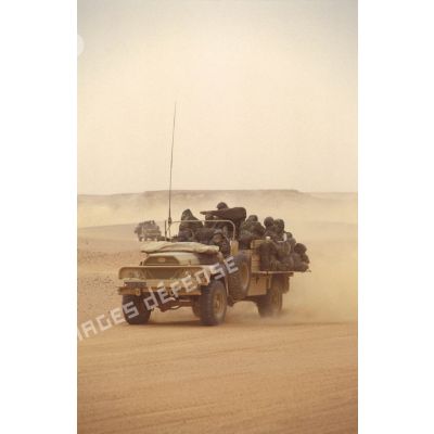Dans le désert en ZDO (zone de déploiement opérationnel) Olive, des CRAP (commando de renseignement et d'action dans la profondeur) se déplacent à bord de VLRA (véhicule léger de reconnaissance et d'appui) débachés, avec des sacs à dos accrochés sur les flancs.