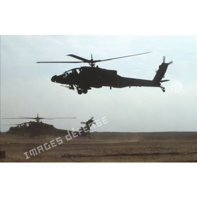 En ZDO (zone de déploiement opérationnel) Olive, deux hélicoptères de combat américains Hughes-AH 64 Apache de retour de mission se posent dans le désert.